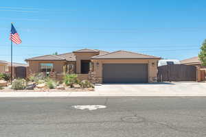 Prairie-style house featuring stucco siding, driveway, a tiled roof, and stone siding