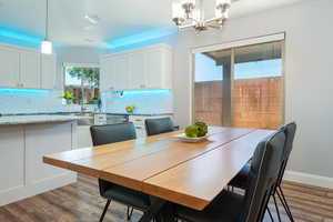 Dining space with light wood-style floors and a chandelier