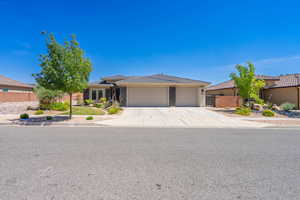 View of front of property with an attached garage, driveway, and a tiled roof