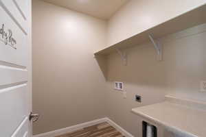 Laundry area with dark wood finished floors, hookup for an electric dryer, and hookup for a washing machine