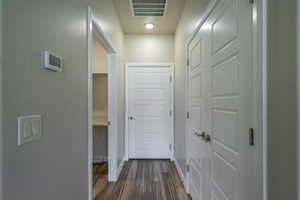 Hall featuring dark wood-style flooring and baseboards
