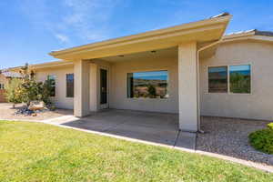Rear view of property with a patio, stucco siding, and a lawn