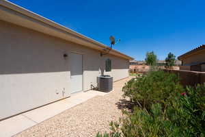 View of side of property featuring a fenced backyard and stucco siding