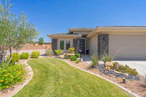 Prairie-style house featuring stone siding, a tile roof, stucco siding, driveway, and a garage