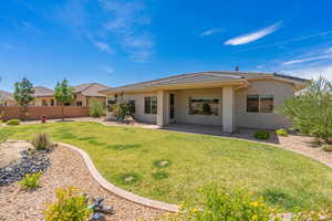 Rear view of property featuring a patio, stucco siding, and a tiled roof