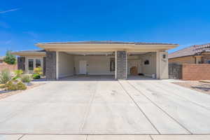 View of front of property with stucco siding, stone siding, and concrete driveway