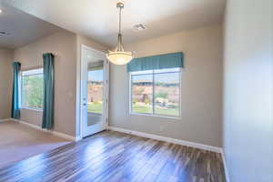 Unfurnished dining area featuring plenty of natural light and wood finished floors