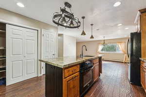 Kitchen with black appliances, dark wood finished floors, decorative light fixtures, recessed lighting, and a textured ceiling