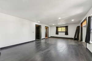 Unfurnished room featuring dark wood-type flooring, recessed lighting, and a textured ceiling
