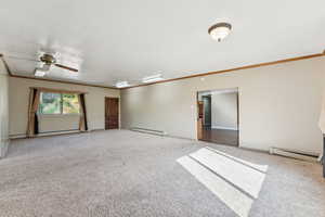 Unfurnished room with ornamental molding, carpet flooring, a baseboard radiator, a ceiling fan, and a baseboard heating unit