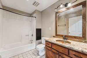 Bathroom featuring tile patterned flooring, shower / bath combination, and vanity