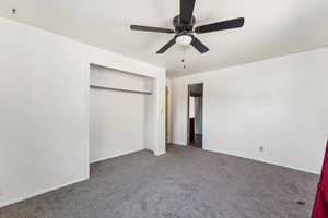 Unfurnished bedroom with carpet floors, a closet, and ceiling fan