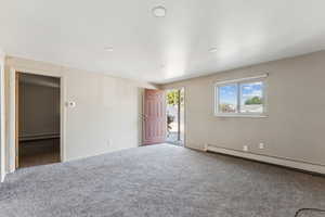 Unfurnished bedroom with carpet, baseboard heating, and recessed lighting