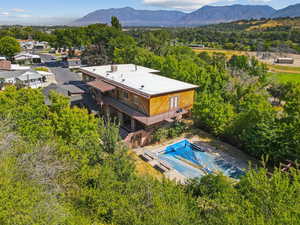 View of subject property featuring a pool area and a mountainous background