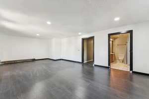 Spare room with wood finished floors, recessed lighting, baseboard heating, and a textured ceiling