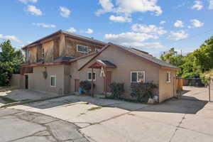 View of front facade with a patio, a gate, and driveway
