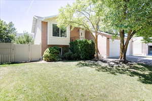 View of front of home featuring brick siding, driveway, and a garage