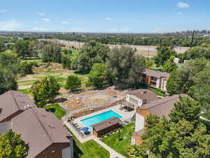 Drone / aerial view of a pool area and a tree filled landscape