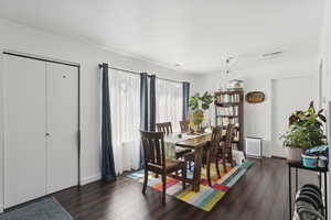 Dining area with dark wood-style floors and baseboards