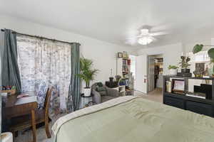 Bedroom with light carpet, a spacious closet, and ceiling fan