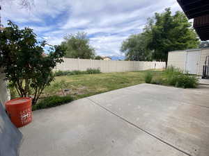 Fenced backyard featuring a patio and an outbuilding