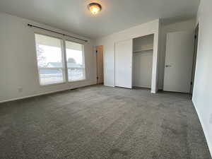 Unfurnished bedroom with carpet and a closet