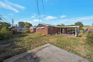 Back of house featuring brick siding and a patio