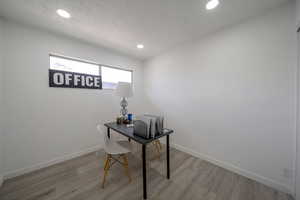 Unfurnished office featuring recessed lighting, light wood-type flooring, and a textured ceiling