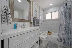 Bathroom with shower / tub combo with curtain, vanity, and recessed lighting