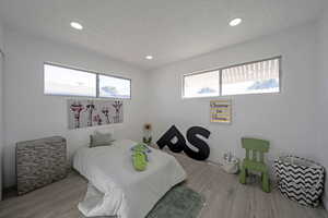 Bedroom featuring wood finished floors, recessed lighting, and a textured ceiling
