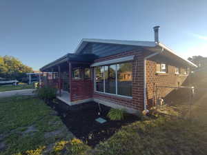 View of home's exterior featuring brick siding and a lawn