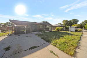 View of front of property with a carport and concrete driveway