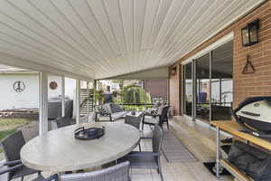 Sunroom / solarium featuring plenty of natural light, outdoor dining area, and vaulted ceiling