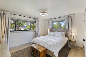 Bedroom with wood finished floors and baseboards