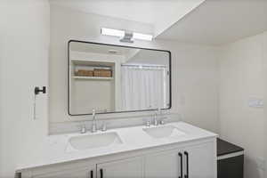 Full bathroom with double vanity and a shower with curtain