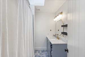 Bathroom featuring vanity and curtained shower