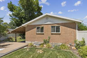 View of property exterior with brick siding and a deck