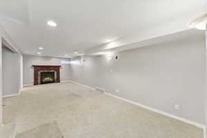 Below grade area with carpet, a fireplace, and recessed lighting