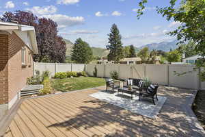 Wooden terrace with a fenced backyard, an outdoor hangout area, and a mountain view