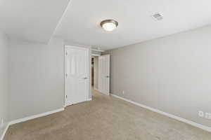 Unfurnished bedroom featuring baseboards and carpet