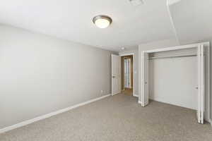 Unfurnished bedroom featuring light carpet and a closet