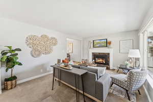 Living room with a high end fireplace and carpet flooring