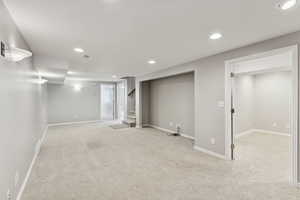 Finished below grade area featuring recessed lighting, carpet, and stairs