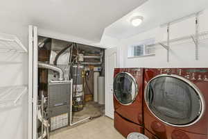 Washroom with washer and dryer, water heater, and heating unit