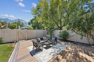 Wooden terrace with a fenced backyard, an outdoor hangout area, and a mountain view