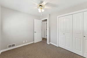 Unfurnished bedroom featuring carpet floors, a closet, and a ceiling fan