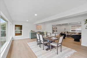 Dining room with light wood finished floors and recessed lighting