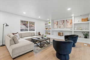 Living area with light wood-style floors, recessed lighting, and built in features