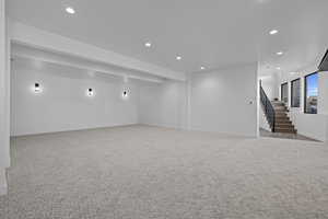 Basement with recessed lighting, stairway, and carpet floors