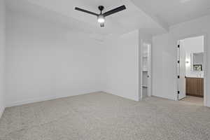 Unfurnished bedroom with light carpet, a spacious closet, connected bathroom, and a ceiling fan